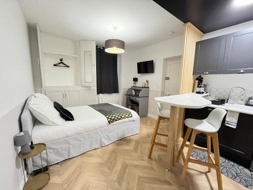 um quarto com uma cama, uma mesa e uma cozinha em Le Studio Haslay SERAUCOURT en plein cœur de ville de BOURGES - Charme de l ancien et confort contemporain em Bourges