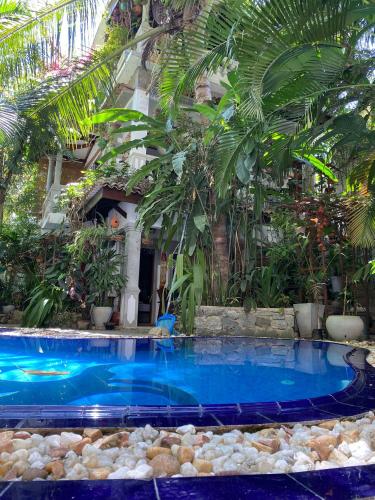 a swimming pool in front of a house with palm trees at Villa Olde Ceylon in Kandy