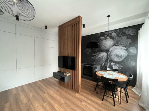 a dining room with a table and a tv at Apartament Serce Miasta in Wrocław