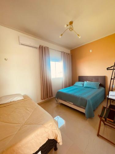 a bedroom with two beds and a window at Residencial Floreana Apto Estrela in Salinópolis