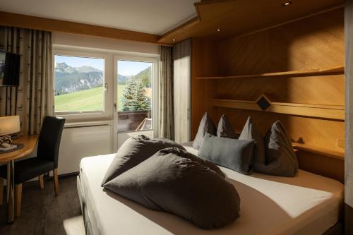 1 dormitorio con 1 cama grande y ventana en Alpen Apartments Austria, en Berwang