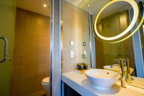 W łazience znajduje się umywalka i lustro. w obiekcie 盛世酒店 Epoch Hotel w Hongkongu