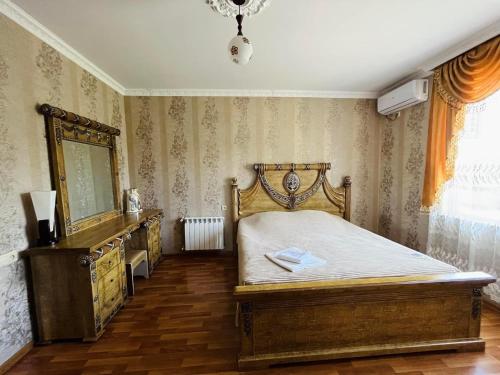a bedroom with a bed and a dresser and a mirror at Hotel Oniks in Kutaisi