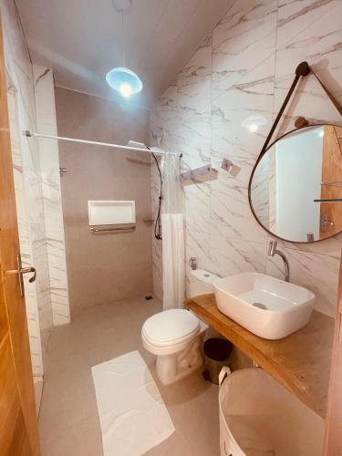 a bathroom with a sink and a toilet and a mirror at Residencial Floreana Apto Estrela in Salinópolis