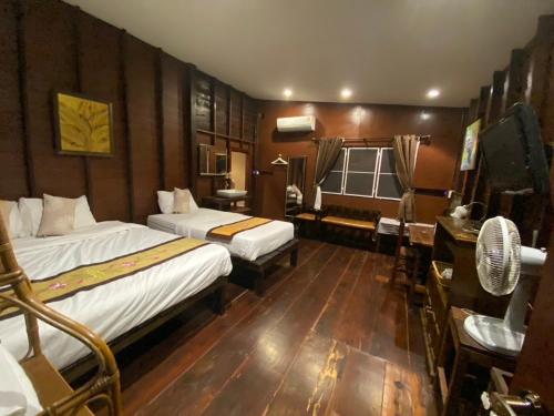 Habitación de hotel con 2 camas y escritorio en Reuan Vilawan en Ratchaburi