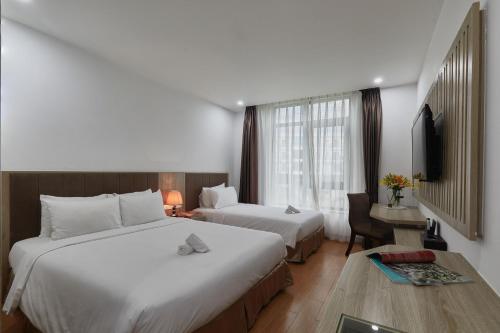 ein Hotelzimmer mit 2 Betten und einem TV in der Unterkunft Genuss Tam Dao - Hideaway Retreats in Tam Ðảo