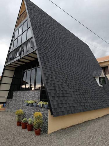 a black roof on a building with potted plants at Eden Cottage in Cochin