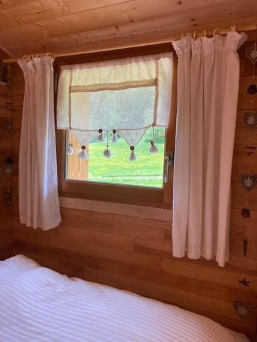 a bedroom with a window with a view of a yard at Gîte insolite, logement fabuleux in Guyans-Vennes