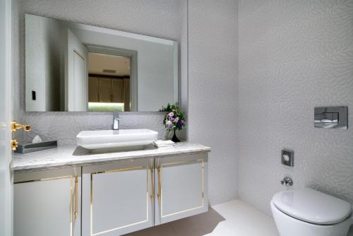 a bathroom with a sink and a toilet and a mirror at Concorde Tower Hotel & Casino in North Nicosia