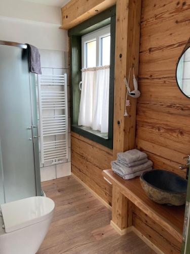 Baño de madera con lavabo y espejo en Penzion Henke en Srbská Kamenice