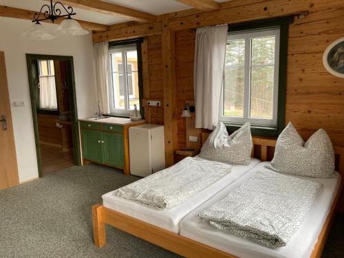 a bedroom with two beds and a refrigerator and windows at Penzion Henke in Srbská Kamenice