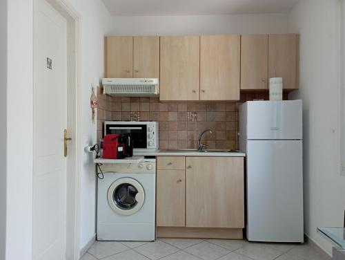 kuchnia z pralką i lodówką w obiekcie Captain's Nest w mieście Andros