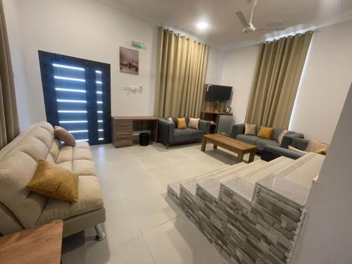 a living room with two couches and a tv at ALOEVERA VILLAS & CAFA in Sayq