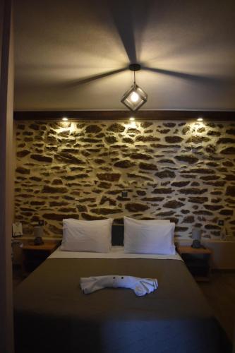 a bed in a room with a stone wall at Chalkidiki AsterGia apartments in Metangítsion