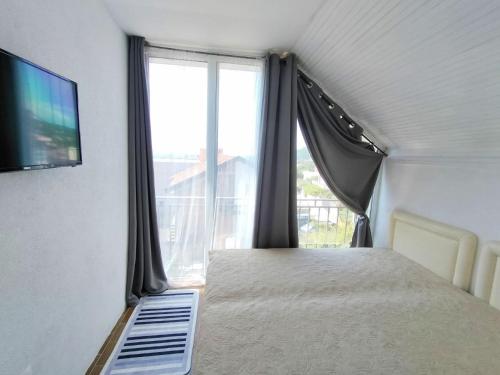 une chambre avec un lit et une grande fenêtre dans l'établissement Арartment IRENA, à Dobra Voda
