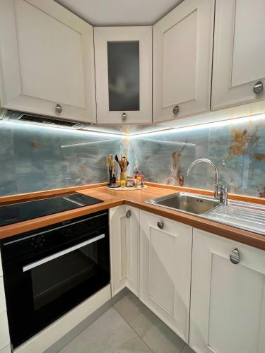 a kitchen with white cabinets and a sink at Cozy flat near the beach in Zoagli