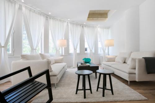 a white living room with a couch and two tables at Angel Main Square Center Zagreb in Zagreb