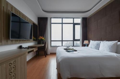 a hotel room with a large bed and a television at Genuss Tam Dao - Hideaway Retreats in Tam Ðảo