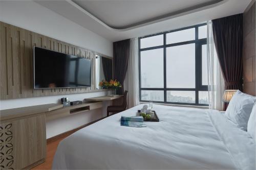 a hotel room with a large bed and a flat screen tv at Genuss Tam Dao - Hideaway Retreats in Tam Ðảo