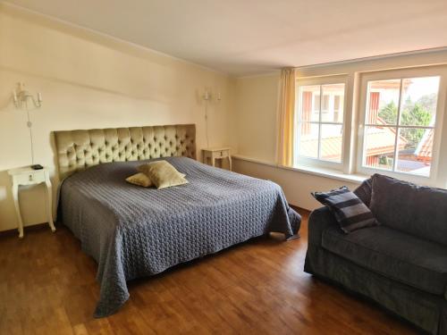 a bedroom with a bed and a couch at Juodasis Kalnas in Juodkrantė