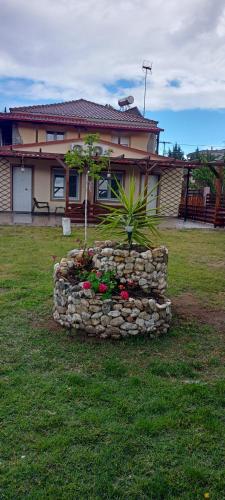 a stone wall with flowers in front of a house at Chalkidiki AsterGia apartments in Metangítsion