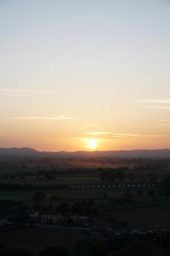 a sunset over a field with the sun in the sky at Casa Stella - Montepulciano in Montepulciano