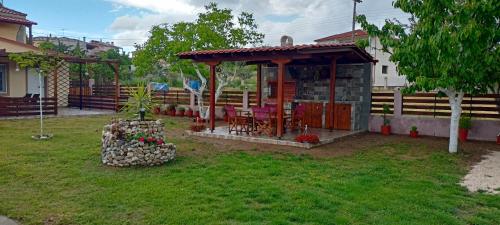 a gazebo with a table and chairs in a yard at Chalkidiki AsterGia apartments in Metangítsion