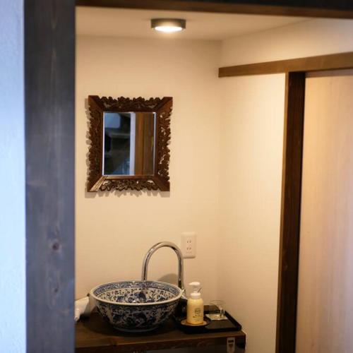 a bathroom with a sink and a mirror at vacation house WAKURA わ蔵 in Tomi