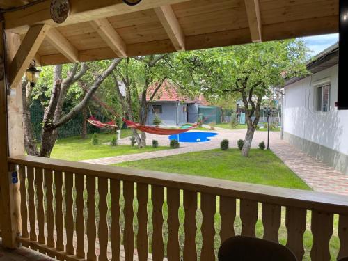 a view of a yard from a porch with a hammock at La Florina in Şuncuiuş