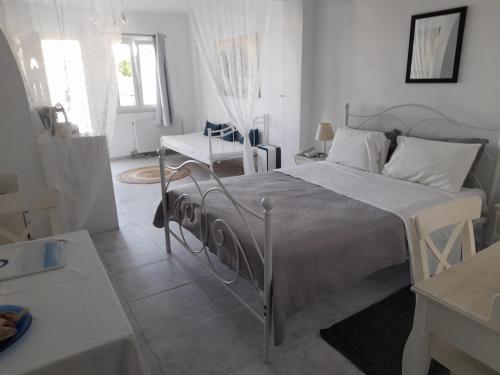 sypialnia z łóżkiem, stołem i krzesłem w obiekcie Sea paradise villas - Seaside & private jacuzzi w mieście Oia