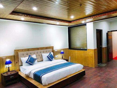 a bedroom with a large bed with blue pillows at zoz star leh in Leh