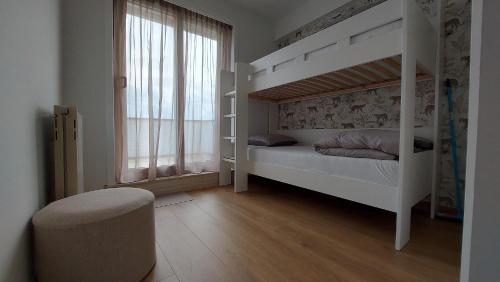 een slaapkamer met een wit stapelbed en een raam bij Beautiful Bruges in Zeebrugge