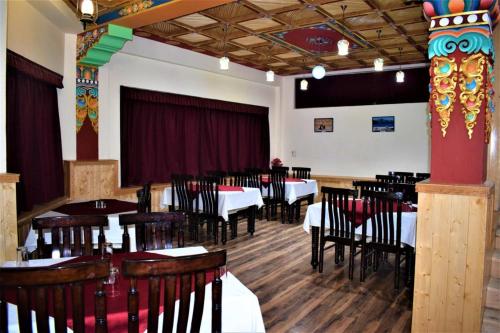 a restaurant with tables and chairs in a room at zoz star leh in Leh