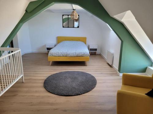 - une chambre avec un lit, un canapé et un tapis dans l'établissement Le St Gemmes : Appartement T3, à Sainte-Gemme-sur-Loire