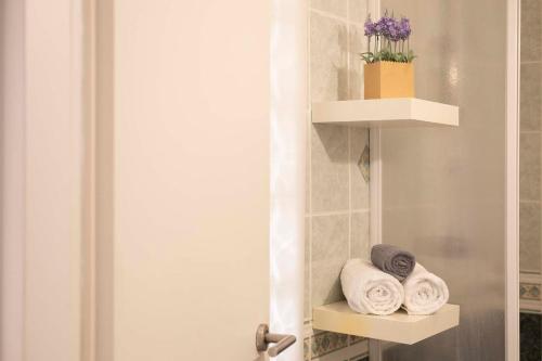 a bathroom with towels on a shelf next to a door at Cefalù, Lascari - Appartamento moderno vicino al mare in Lascari