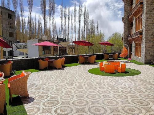 a patio with tables and chairs and umbrellas at zoz star leh in Leh