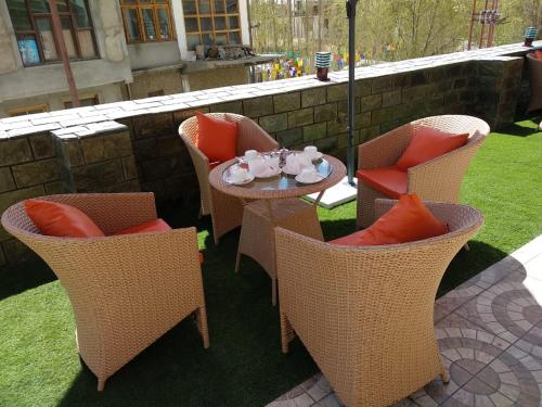 a patio with chairs and a table and an umbrella at zoz star leh in Leh