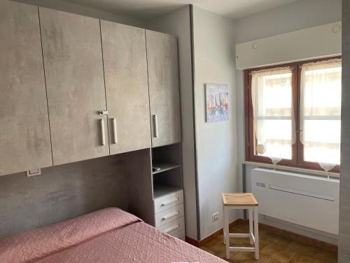 una camera con letto, finestra e armadi di Scacciapensieri house a Nettuno