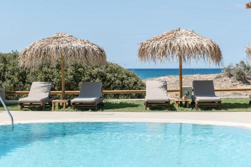 a group of chairs and umbrellas next to a swimming pool at Golden Sand in Plaka