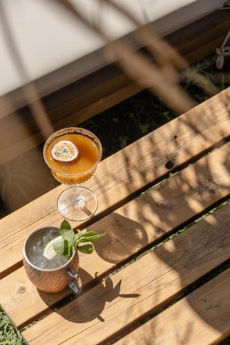 a drink sitting on a wooden table with a plant at Golden Sand in Plaka