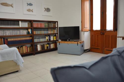a living room with a tv and book shelves at CaTó - Le vacanze come a casa tua in Carloforte
