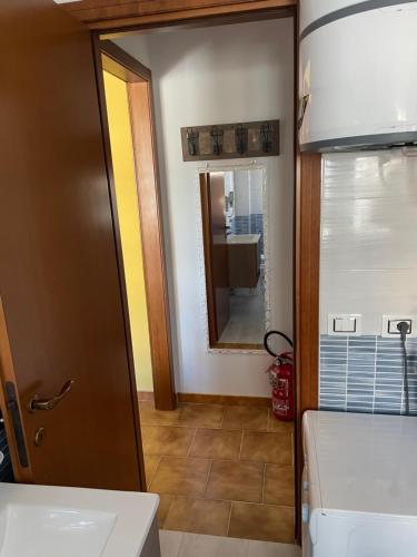 un bagno con uno specchio, un lavandino e un water di Scacciapensieri house a Nettuno