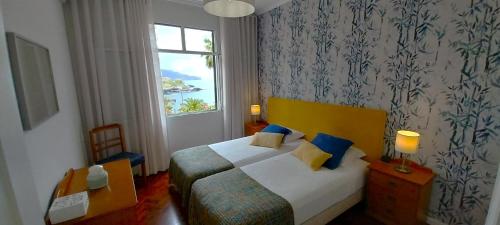 Habitación de hotel con cama y ventana en Vila Calaça, en Funchal