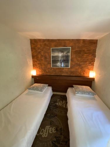2 Betten in einem kleinen Zimmer mit einem Bild an der Wand in der Unterkunft Domek przy Promenadzie Zdrojowej in Goldap