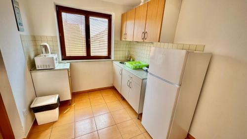 a kitchen with a white refrigerator and a window at Vinný Sklep Monty Velké Bílovice in Velké Bílovice