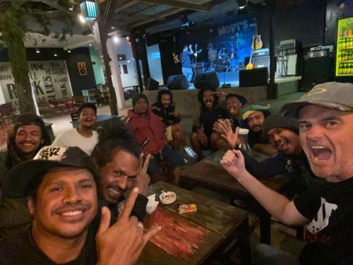 a group of people sitting in a bar posing for a picture at FARILA LODGE in Kelimutu
