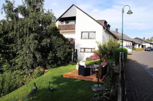 uma pessoa sentada num banco em frente a uma casa em Haus Starkenburg em Enkirch