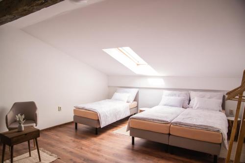 a bedroom with two beds and a chair at Ubytovanie CA - comfy apartments in Čadca