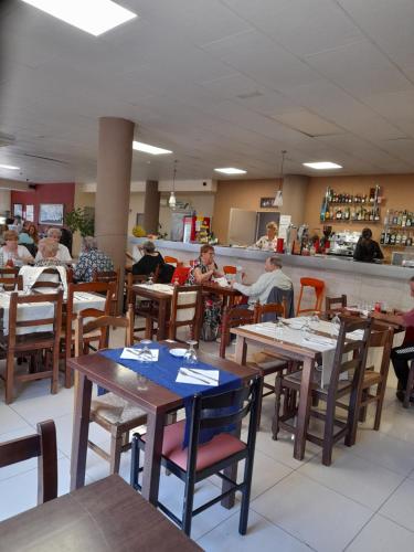 un grupo de personas sentadas en mesas en un restaurante en Hotel l'Albera en La Jonquera