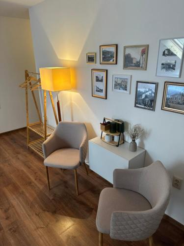a living room with two chairs and a lamp at Ubytovanie CA - comfy apartments in Čadca